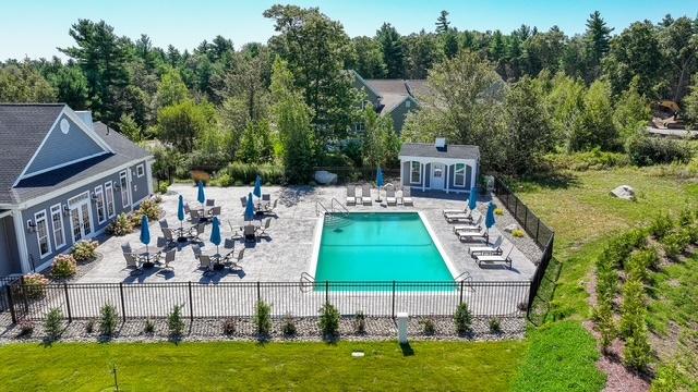 Resort-style pool patio at the Trailside Estates active adult community, surrounded by mature wooded grounds
