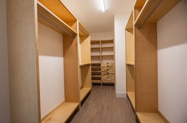 Custom-built walk-in closet inside the first-floor primary suite of a Trailside Estates 55+ luxury condominium