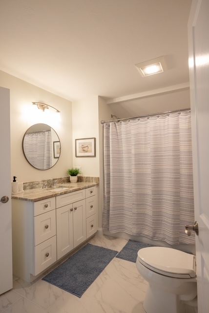 Second-floor full bathroom with stone counter and tub-shower combination at Trailside Estates 55+ luxury condominium